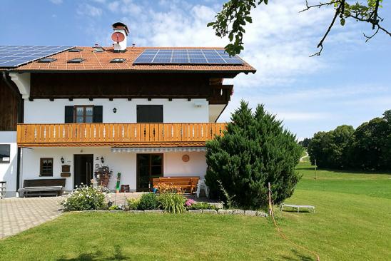 In Regionen mit hoher Sonneneinstrahlung arbeitet die PV-Anlage auf Hochtouren. Haus im Alpenvorland mit Solaranlage
