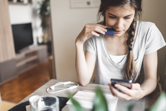 Junge Frau mit Bankkarte und Handy