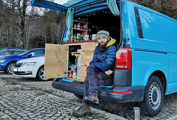 Felix sitzt neben der Küche hinten im Camper