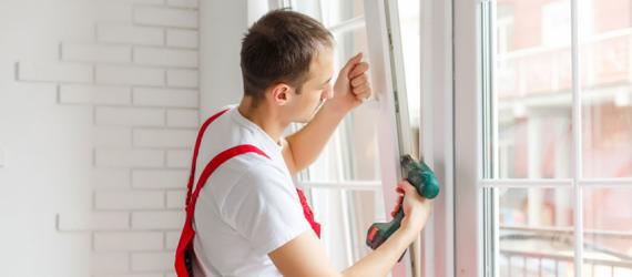 Förderung neue Fenster: Mann baut neues Fenster ein