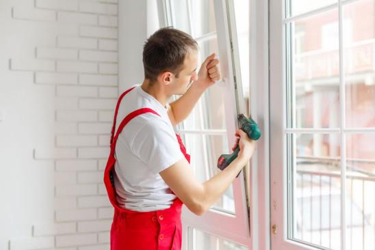 Förderung neue Fenster: Mann baut neues Fenster ein