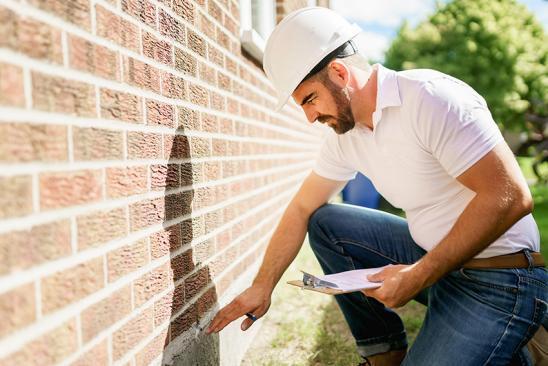 Energieberater prüft Fassade eines Hauses