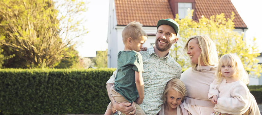 Familie mit Kindern vor Einfamilienhaus