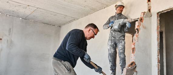 Zwei Handwerker sanieren eine Wand