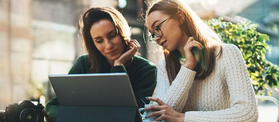 Zwei Frauen schauen in einen Laptop