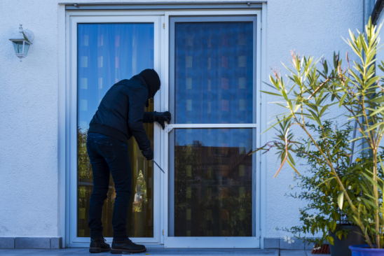 Einbrecher öffnen Hintertür eines Hauses