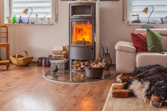 Heizen mit Holz: brennender Kaminofen im Wohnzimmer