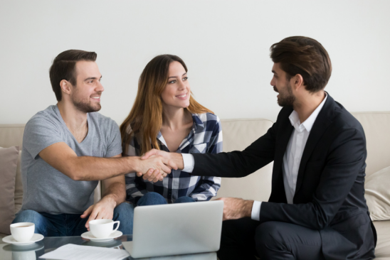 Junges Paar beim Beratungsgespräch mit einem Immobilienmakler