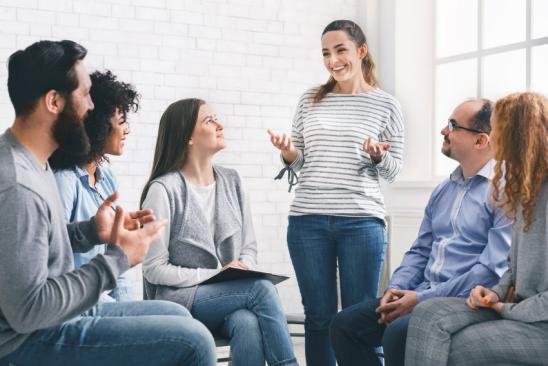 Personen sitzen im Kreis und diskutieren