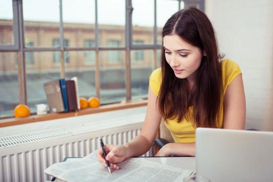 Junge Frau liest Zeitung