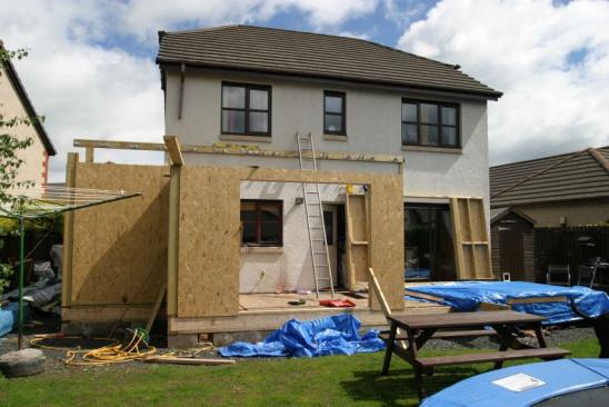 A modern home with an extension being built