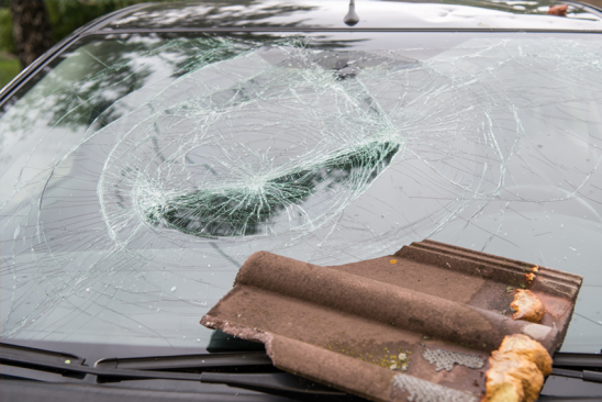 Dachziegel auf kaputter Autoscheibe