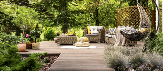 Wohnliche Holzterrasse umgeben von viel Grün